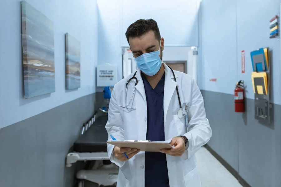 doctor looking at file in a hospital hallway