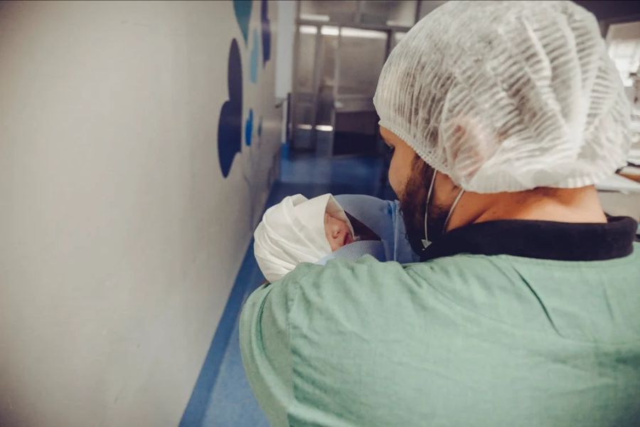 man holding newborn baby