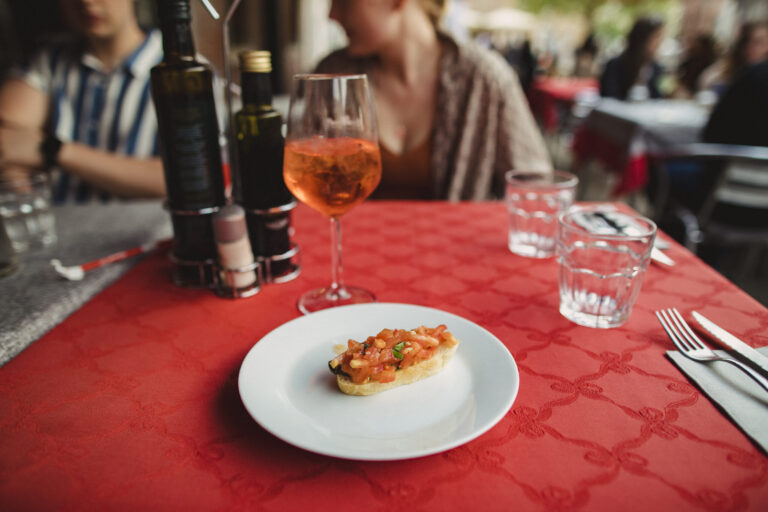 A front view of a plate of bruschetta on a table in a restaurant.