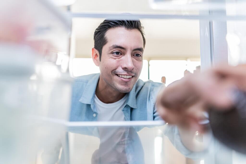 adult man choosing something from the fridge in the kitchen at home