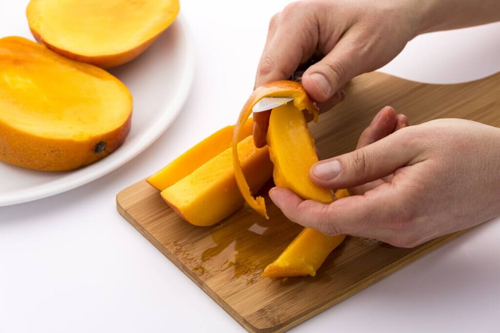 hand peels mango