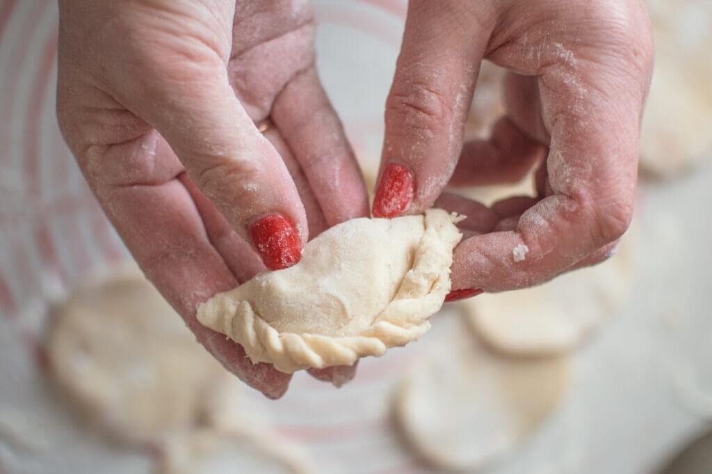 female hands holding raw dumpling