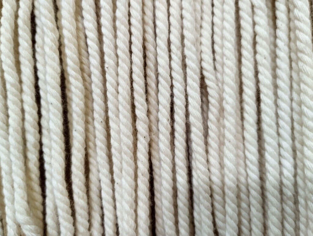 fluffy abstract background of white beige rope-shaped fabric