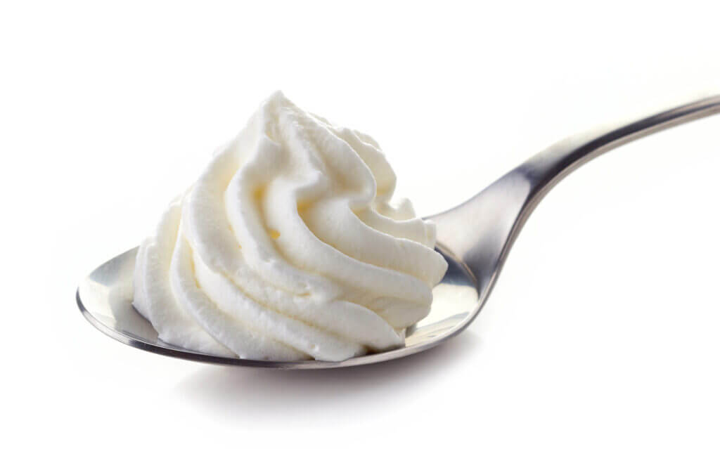 whipped cream in spoon isolated on white background