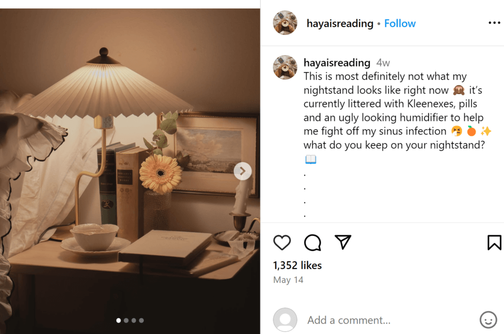 Peaceful antique-themed end table with a fan lamp, several books, and small vase containing a single yellow flower, and a teacup. 