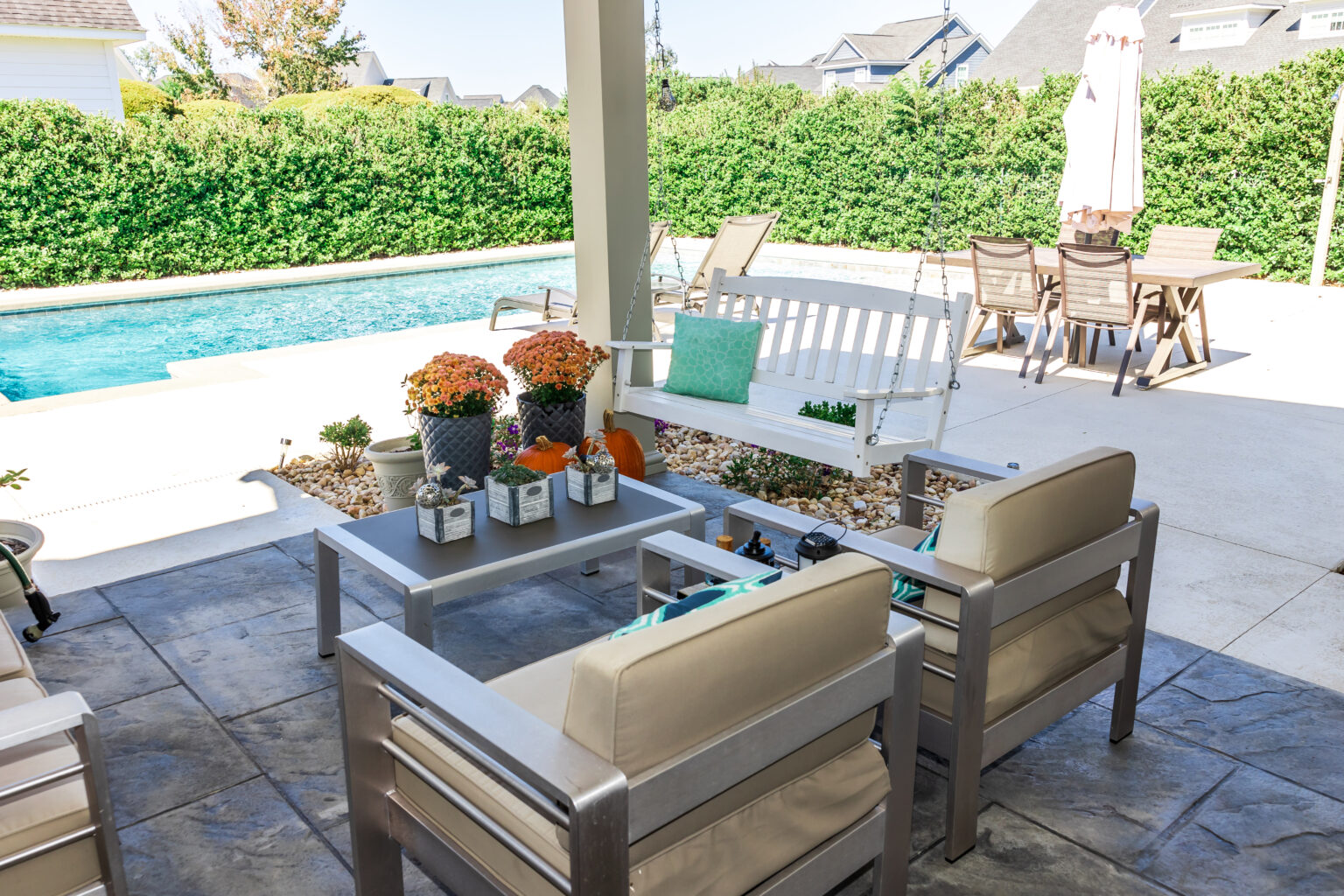 Covered outdoor patio in a new construction house home with guest seating.