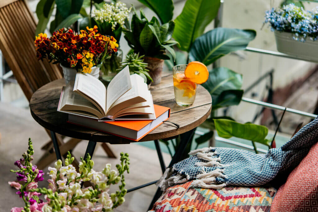 Reading books in summer at a beautiful terrace or cozy balcony full of green plants.