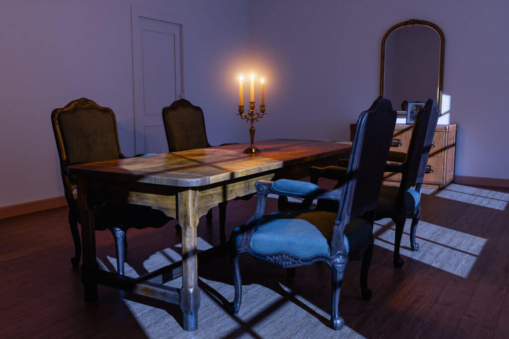 A vintage dining table and chairs sit in the center of a large, old-style room.