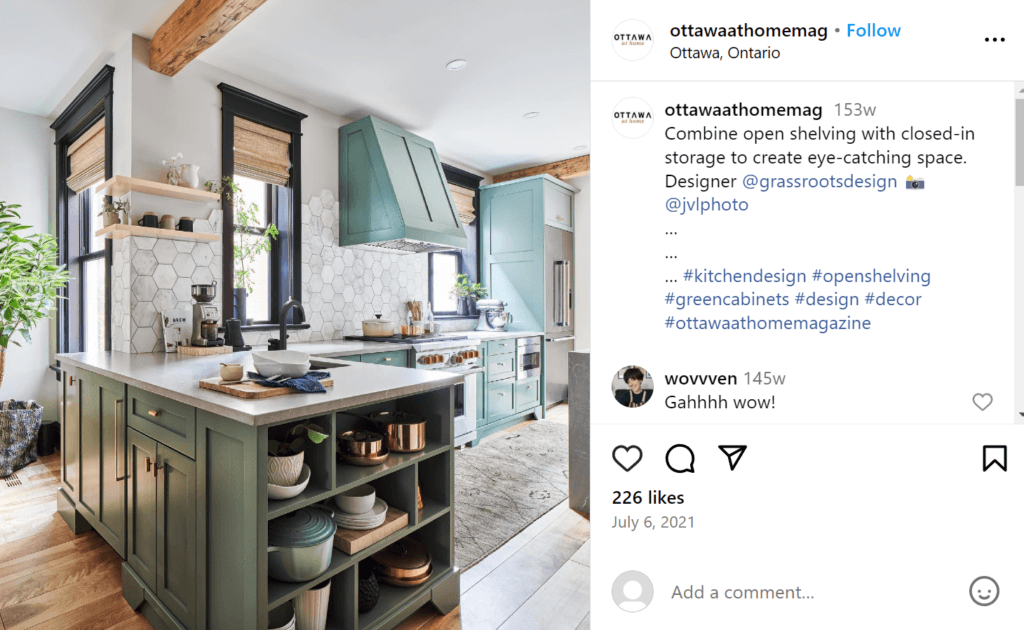 Beautiful modern kitchen with moss green cupboards featuring open cubby shelving on the counter end