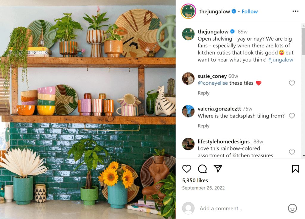 Colorful trinkets and dishes on open shelves on a kitchen wall above a teal tile backsplash