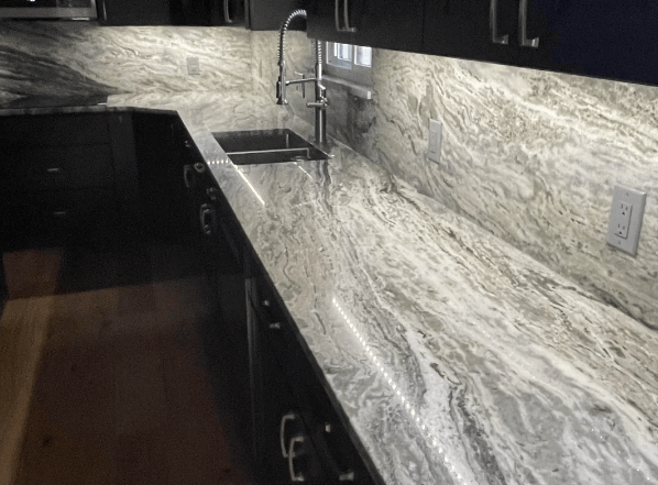 Granite countertop with granite backsplash in black kitchen