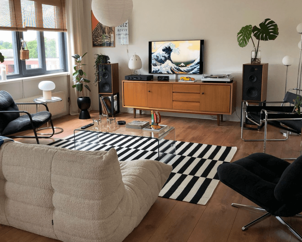 Modern living room with low furniture and a black-and-white striped statement rug.