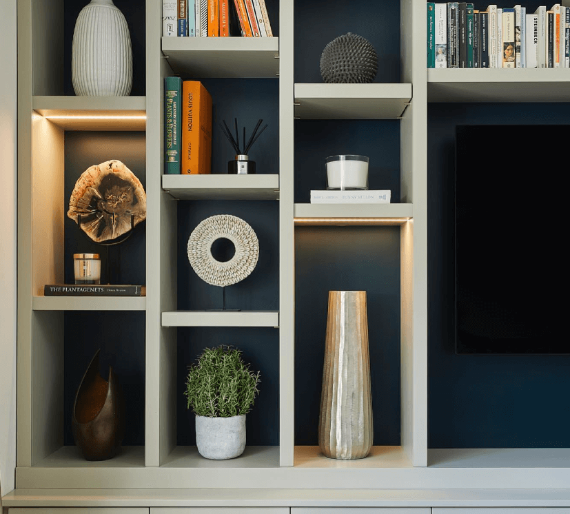 White cubby shelving around a television. The cubbies have navy blue painted backs.