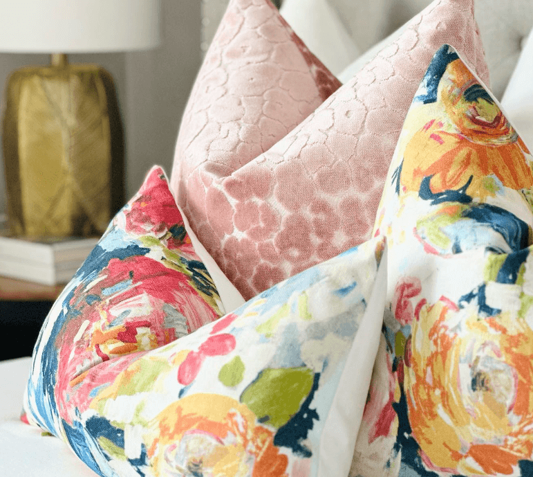 Brightly colored decorative throw pillows on a bed