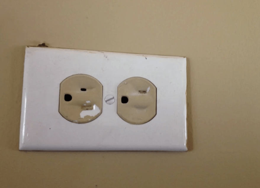 A bad DIY-painted outlet with the holes covered with paint