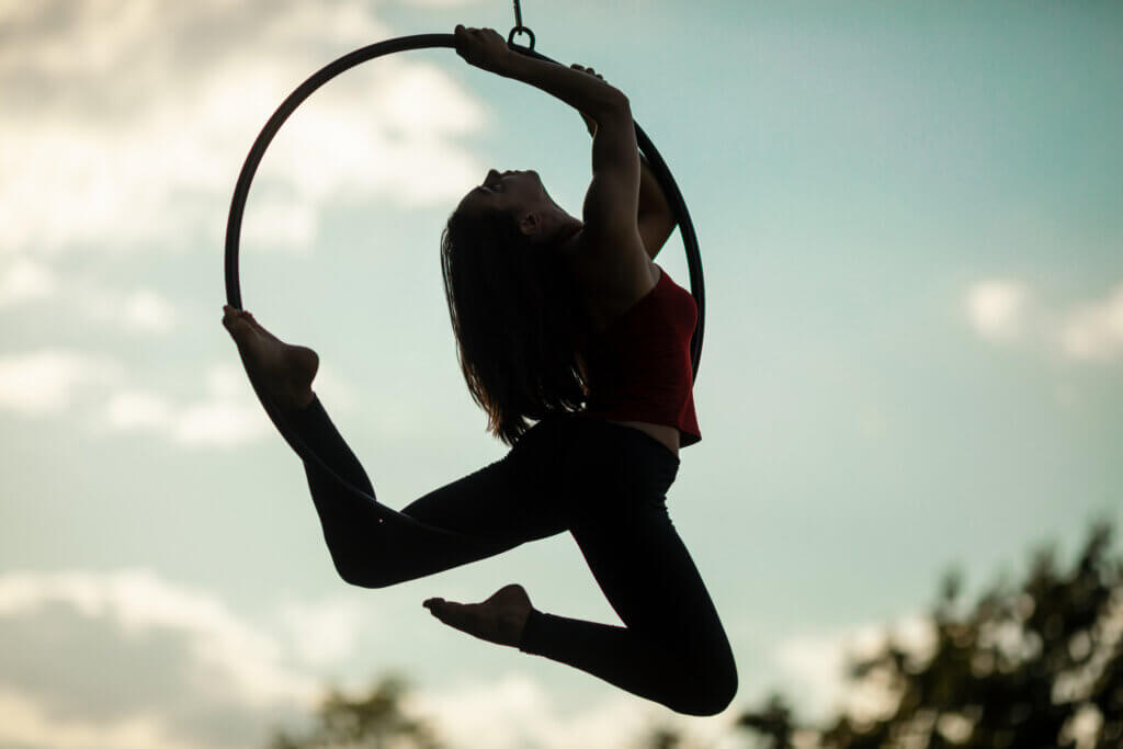 Young woman doing aerial hoop dance in nature