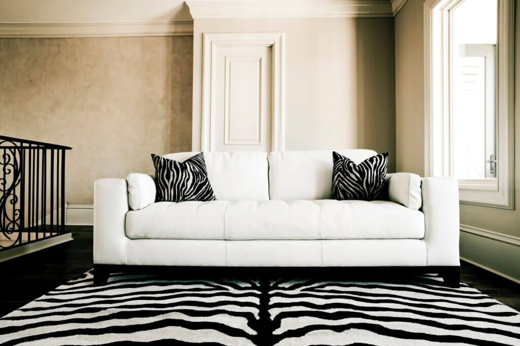 white couch with zebra print rug and pillows