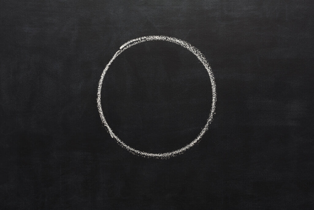 White chalk hand drawing circle on blackboard. Geometrical shape on black educational background with copy space