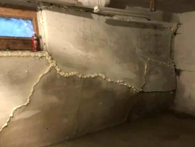 Crumbling, cracking foundation with spray foam covering the cracks