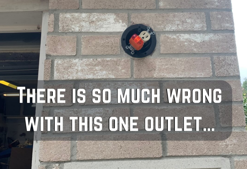 An electrical outlet installed haphazardly on an exterior brick wall, with visible gaps and an uneven mounting. The image is overlaid with text saying, "There is so much wrong with this one outlet," emphasizing the poor installation job.