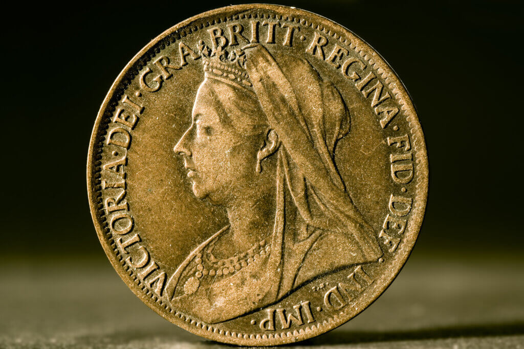 "The back of an antique one-penny coin from the British imperial era, showing the profile of Queen Victoria."