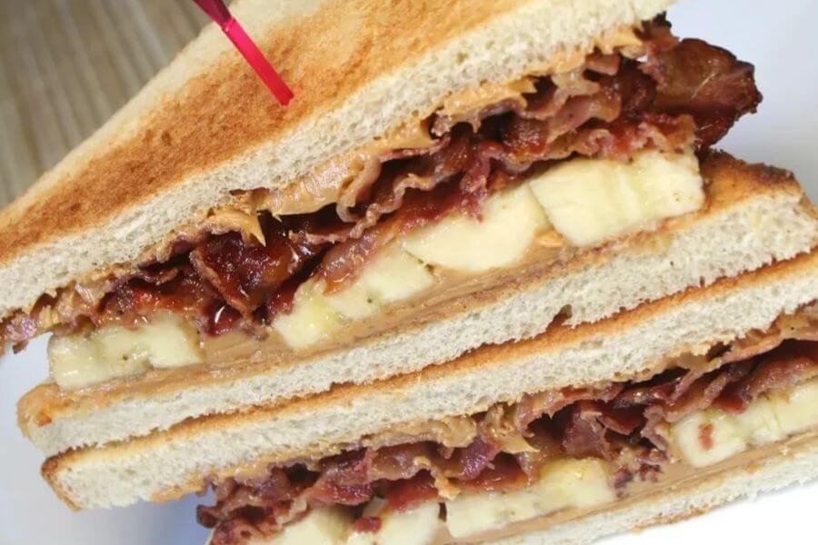 A Peanut Butter, banana and bacon sandwich sliced in half. 