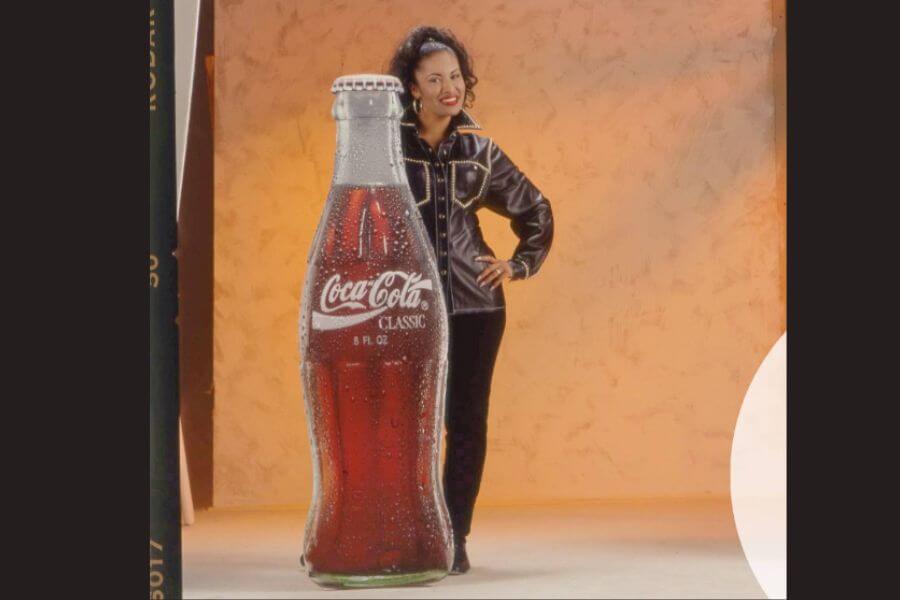 Selena possing with a coca-cola sign