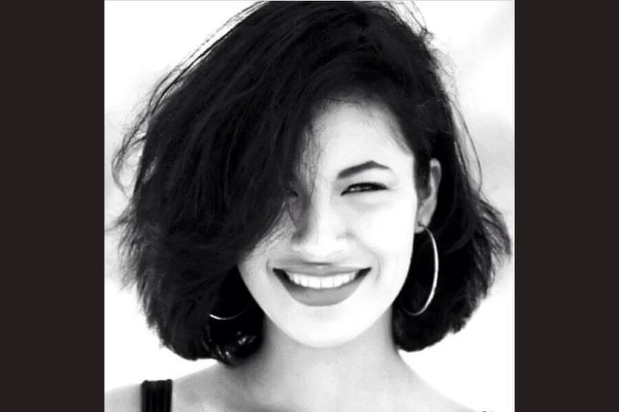 Black and white portrait of a teenage selena smiling at the camera