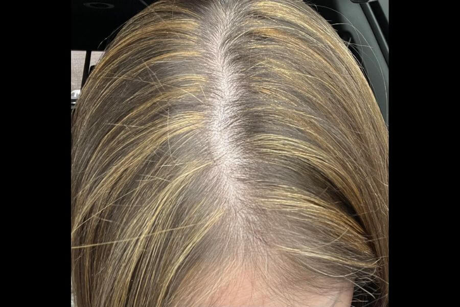 Close up of the top of the head of a women with chuncky yellow high lights