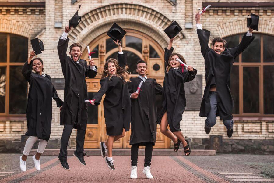 Group of young people jumping on their graduation day