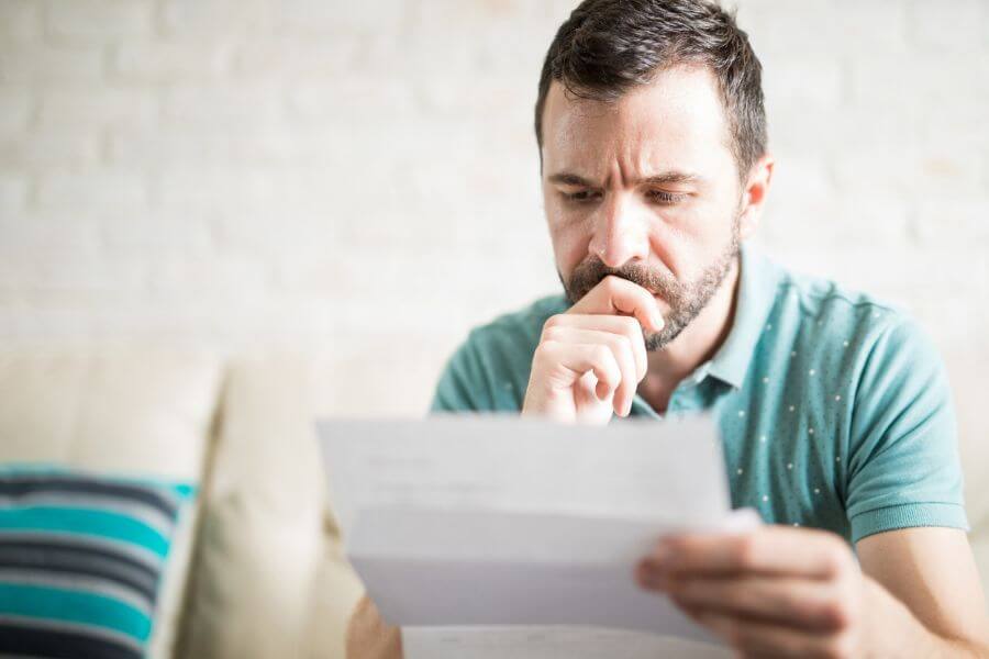 worried looking man reading a document