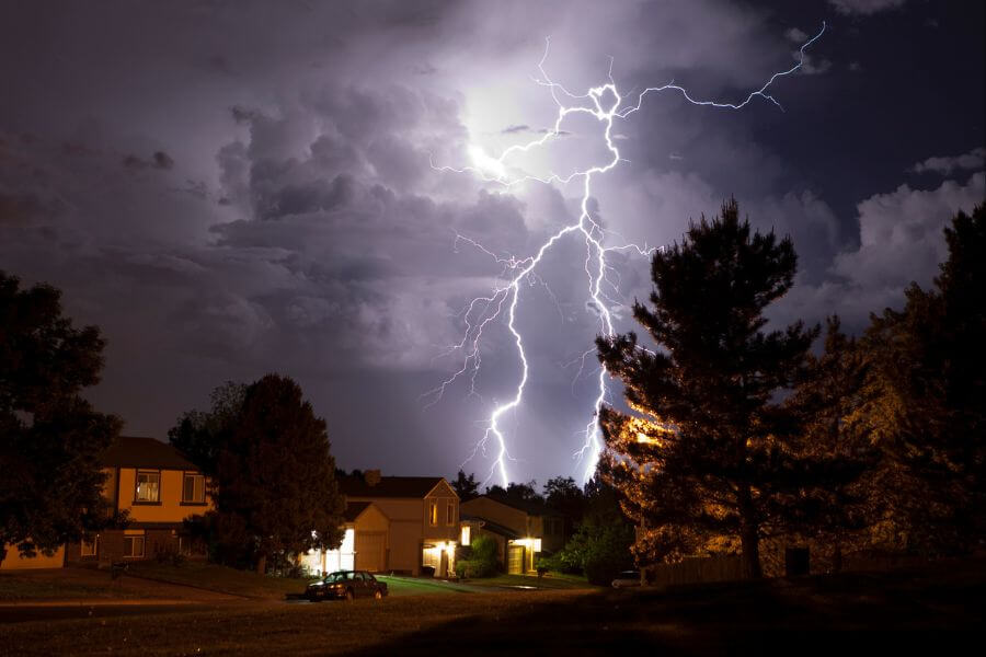 Lightning bolt and thunderhead storms over Denver neighborhood homes