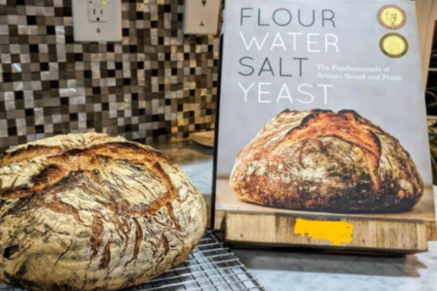 Big round loaf of bread in front of book