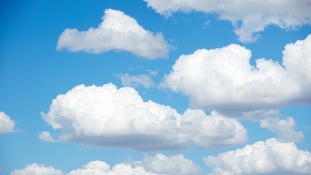 Blue skies with summer cumulus clouds.