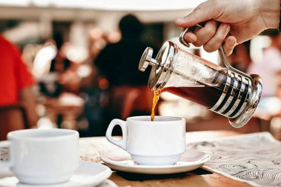 hand pouring coffee on a mug