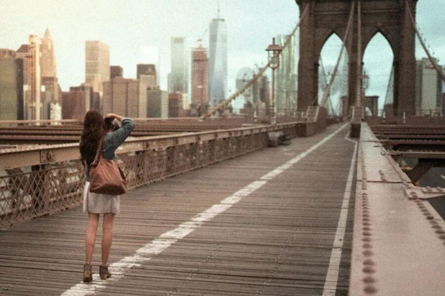 woman takinhg a picture on a bridge