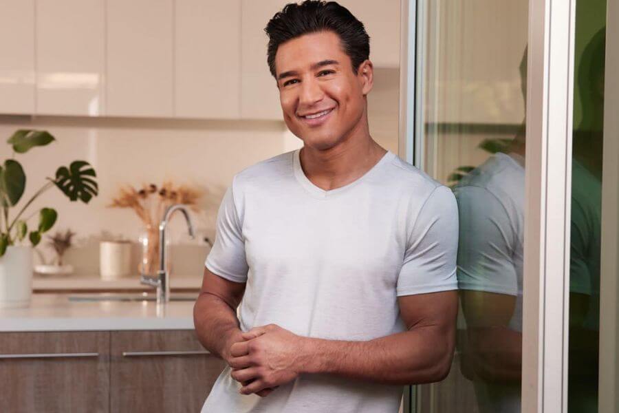 Mario Lopez smiling while standing on his kitchen