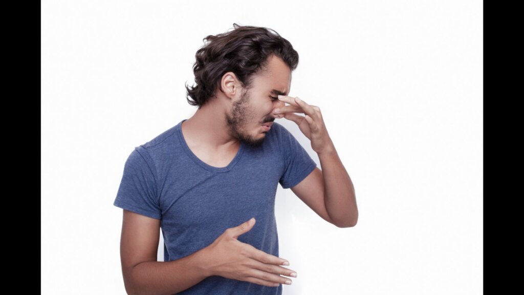 Portrait of man holding his nose.