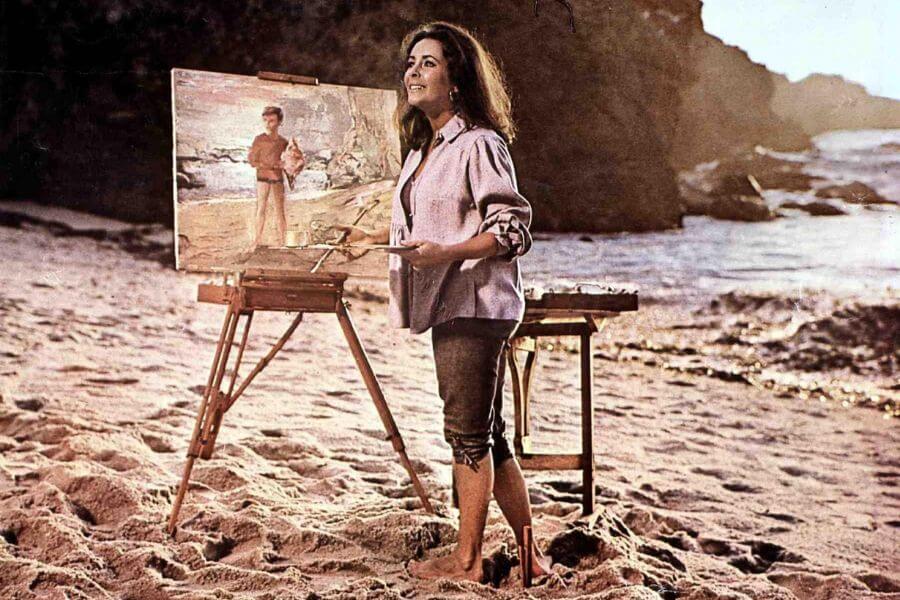 Elizabeth Taylor painting a painting at the beach