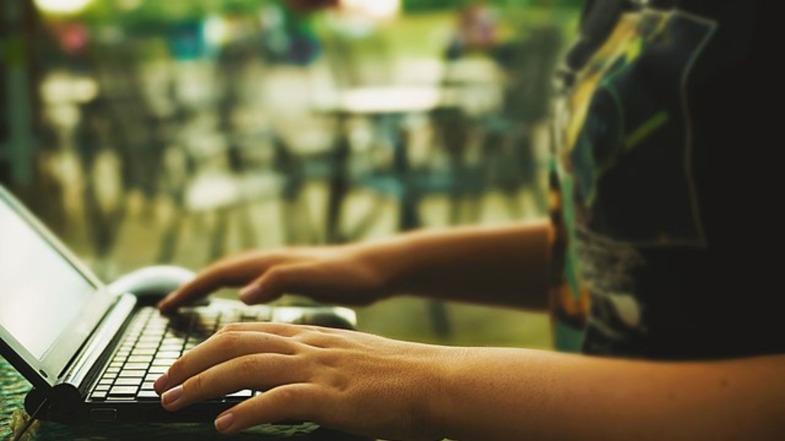 A hand on a laptop.