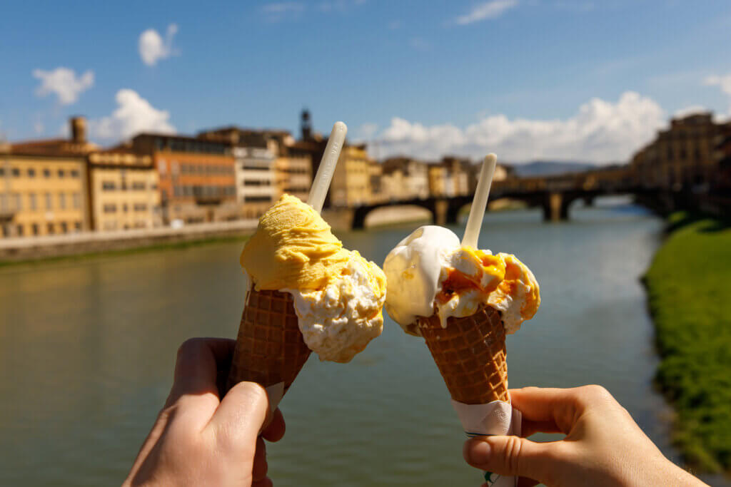 Traveling as a couple. Two cones of Italian ice cream on the city background