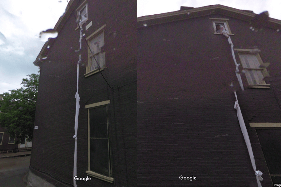 This image shows the side of a building with a makeshift "rope" made of tied cloths hanging from a second-story window, with a person visible in the window holding onto the cloth. The setup resembles an escape attempt or a staged scene, giving the impression of someone trying to climb down or symbolically flee from the building.