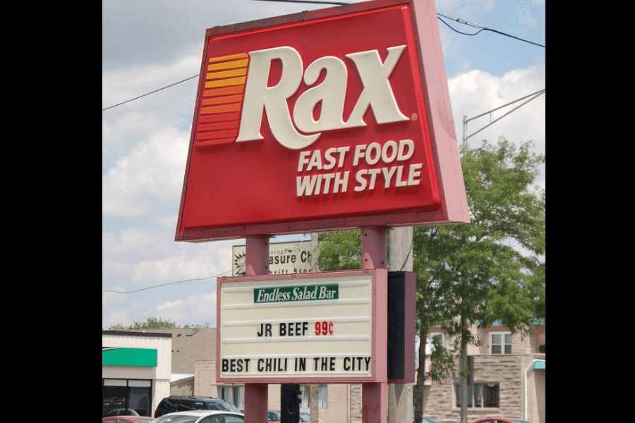 The image displays a Rax restaurant sign featuring the tagline "Fast Food with Style." The marquee highlights offerings like the "Endless Salad Bar," a "JR Beef" sandwich for 99¢, and claims of the "Best Chili in the City."