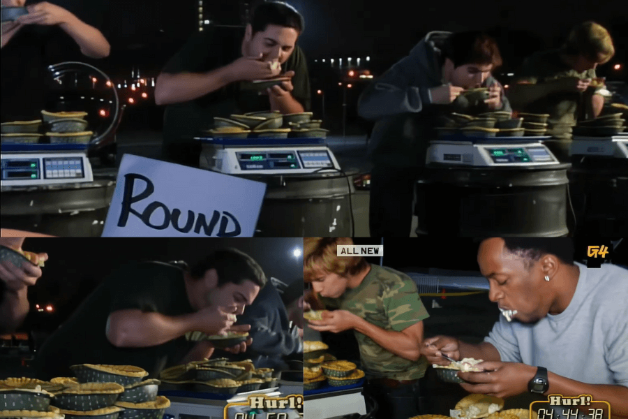 The image shows contestants on the game show Hurl! engaged in a competitive eating challenge, devouring pies as quickly as possible. 