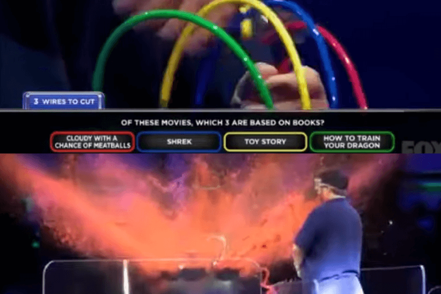 The image shows a contestant on the game show BOOM!, where they answer trivia questions by cutting colored wires attached to a “bomb.” The question on screen asks about movies based on books, and each correct wire cut defuses part of the “bomb.” However, a wrong answer results in an explosive burst of colored powder, creating a dramatic and messy consequence.