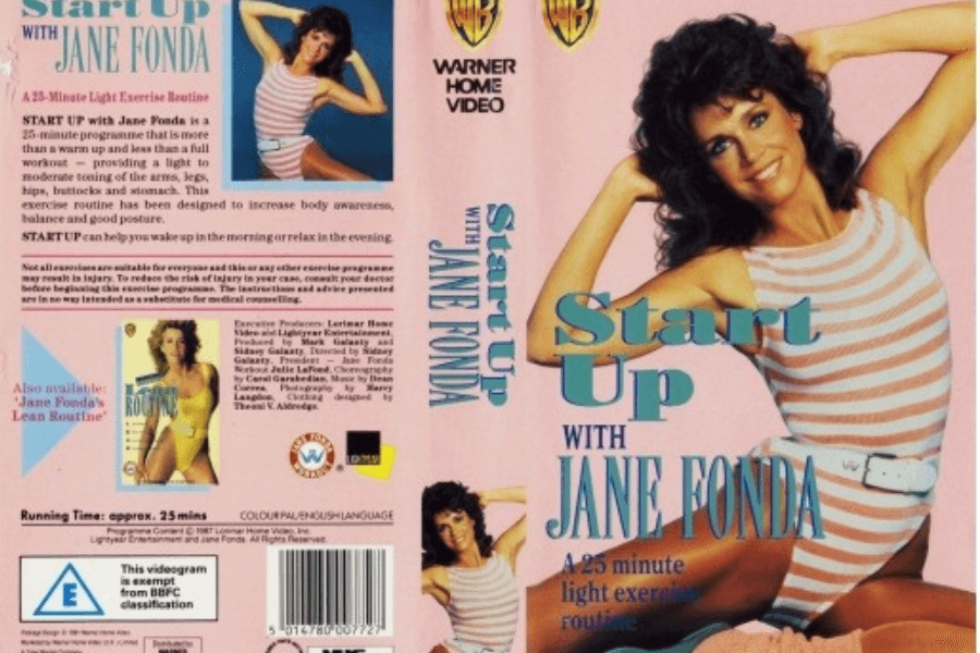 This image is the cover of Jane Fonda's iconic workout video, "Start Up with Jane Fonda," a 25-minute light exercise routine that features Fonda in a striped pink leotard, radiating her signature energy and fitness inspiration of the 1980s.