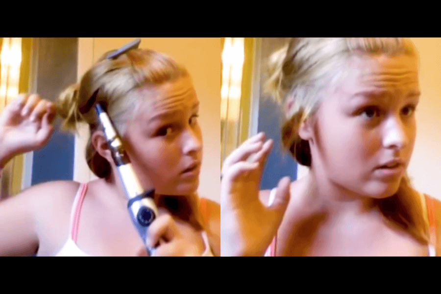 In an attempt to master effortless curls, she bravely wraps her hair around the curling iron, only to be left with a burnt strand and a face full of confusion.