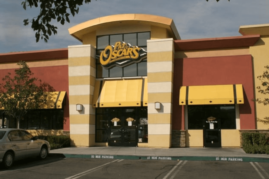 This image features the exterior of a Pat & Oscar's restaurant, known for its vibrant yellow accents, inviting awnings, and modern architecture, evoking memories of their famous breadsticks and family-friendly dining atmosphere.