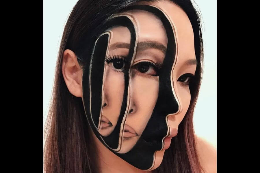 woman drawing faces on her face 3d makeup