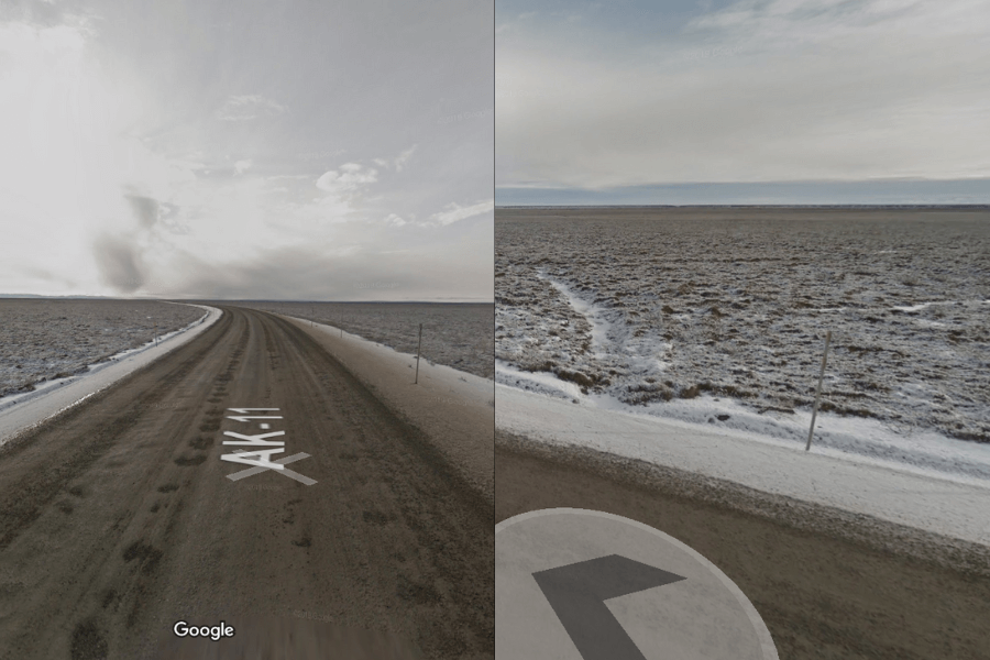 This image shows a desolate, snow-dusted road stretching across an expansive, flat tundra landscape under a cloudy sky. The remote, empty surroundings give an impression of isolation and harsh environmental conditions, likely in a cold, northern region.